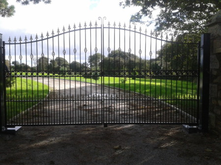 Pair of arch top estate gates with underground automation,decorated with circles, cages and railheads.