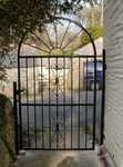 Iron  arch top gate with decorative scroll patterns by Kevin Gerry